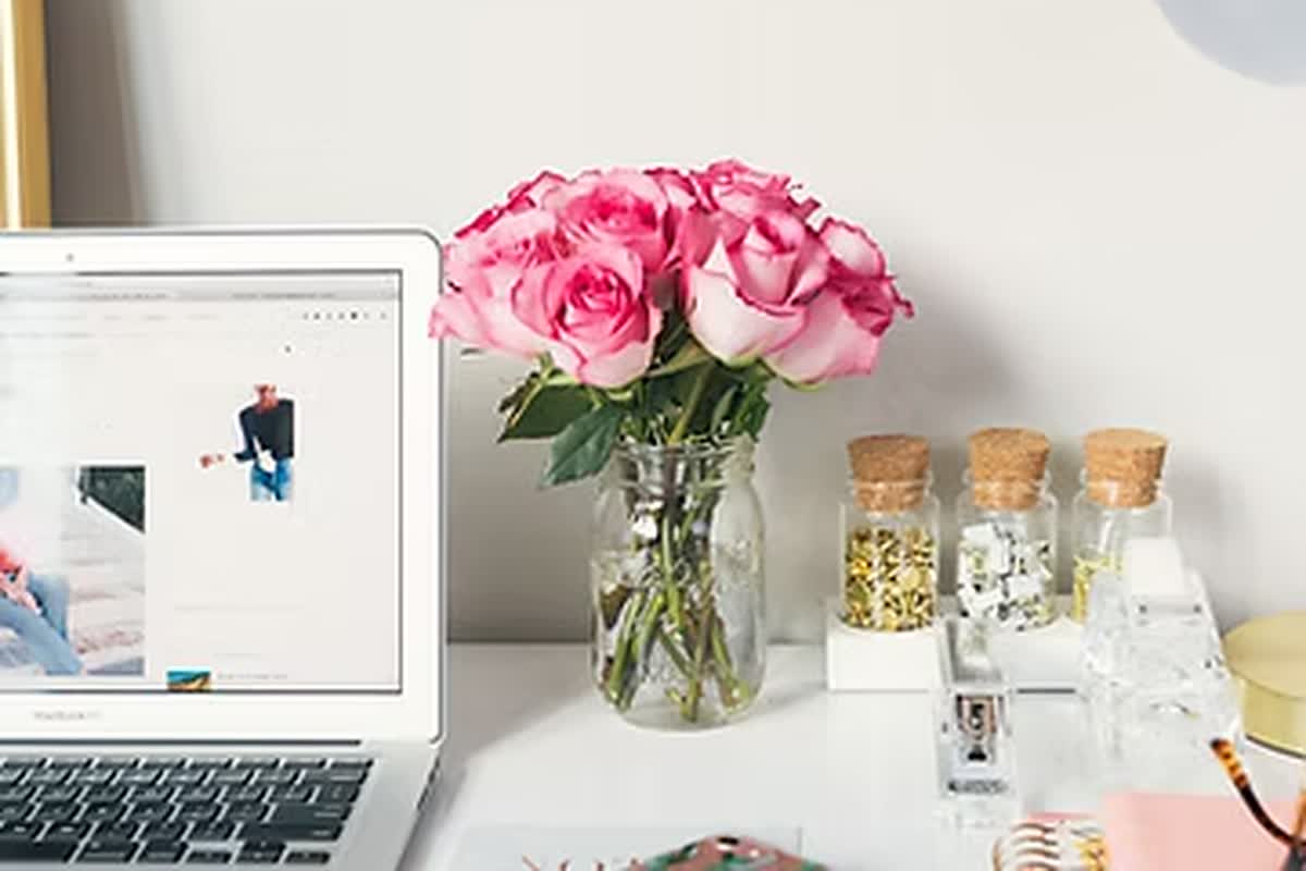 Arbeitsplatz mit Laptop, auf dem der Andreaktiv-Blog geöffnet ist, daneben eine Vase mit rosa Rosen