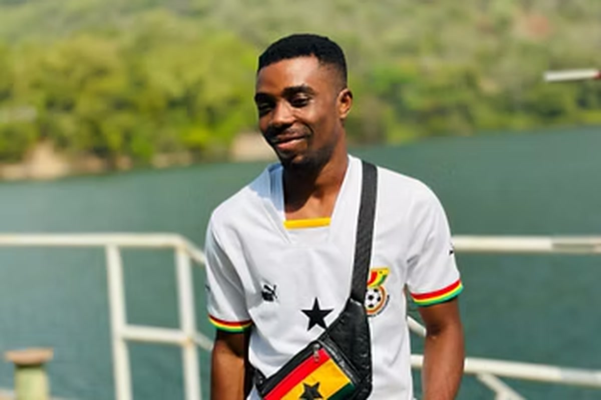 Frank mit Ghanas Nationalmannschafts-Trikot auf einem Boot in Westafrika