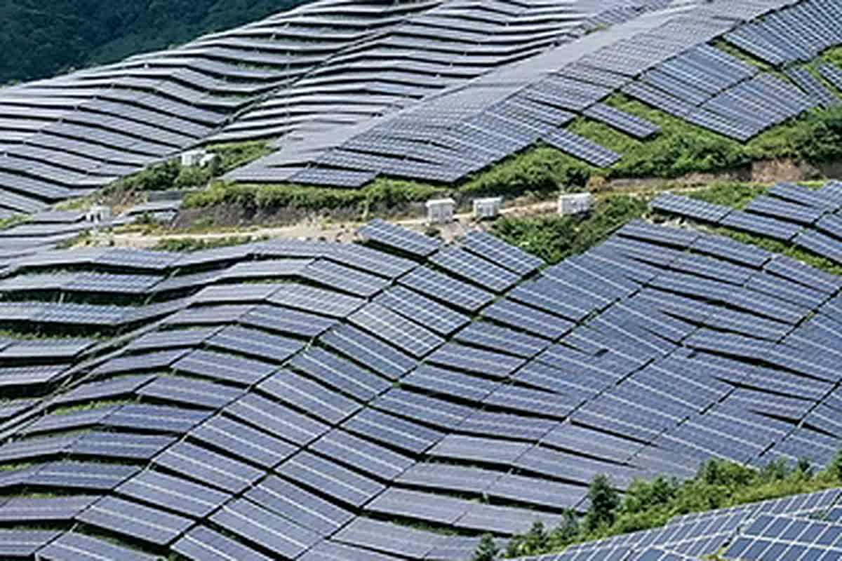 Solarpark mit Panelreihen auf einer Hügellandschaft